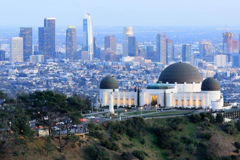 The Griffith Observatory overlooking the Los Feliz neighborhood with the Los Angeles skyline in the background