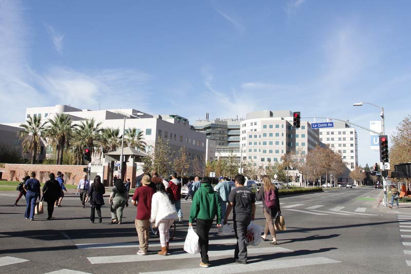 People crossing the intersection of Westwood Plaza and Le Conte Ave on the UCLA campus. 