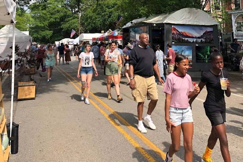 People walk in the street during Inman Park Fest