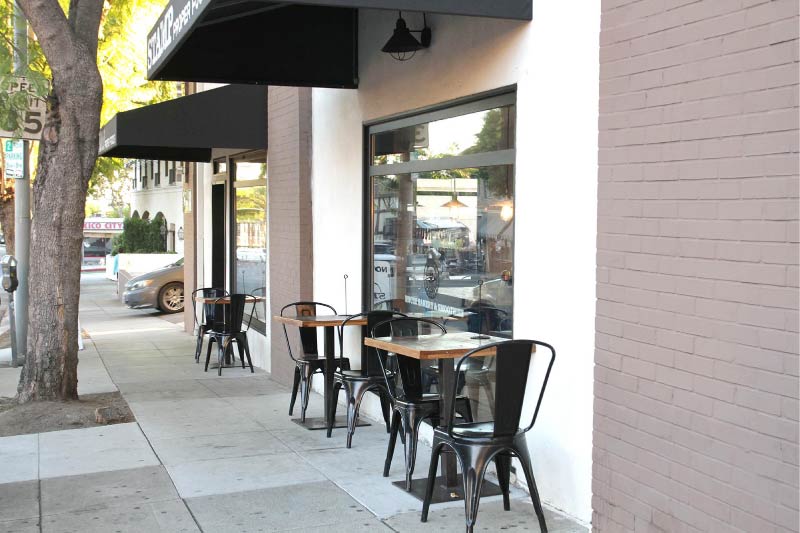 The outdoor seating for Stamp, a vegan restaurant in Palms, Los Angeles. 