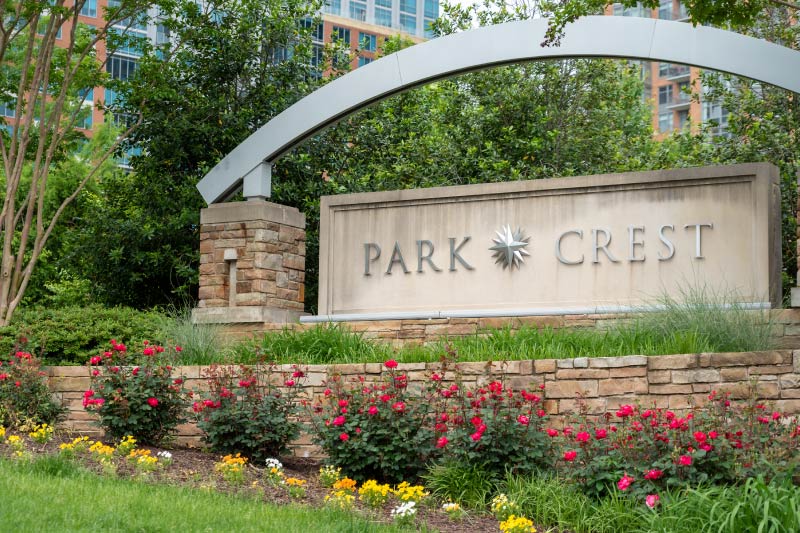 Greenery and flowers surrounding the sign for The Park Crest development in McLean, Virginia