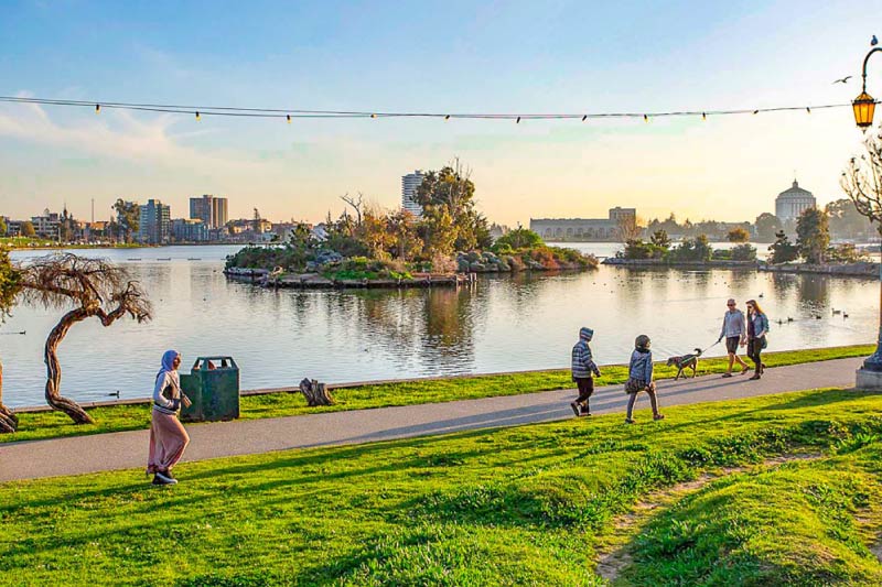 People walking along the pathway bordering Oakland's Lake Merritt. 