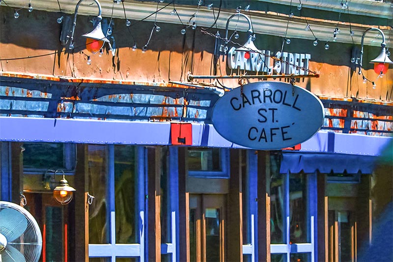 A close-up of the facade of a building with a sign that says Carroll St Cafe
