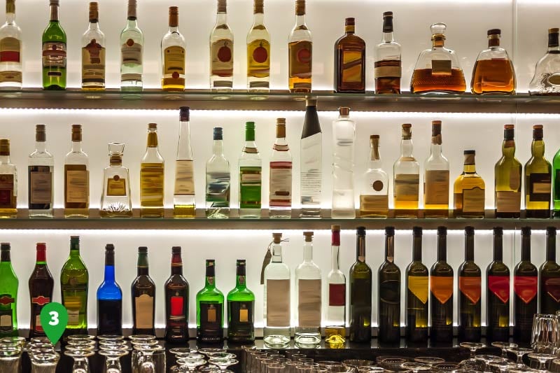 The back of a bar lined with various types of alcohol. 