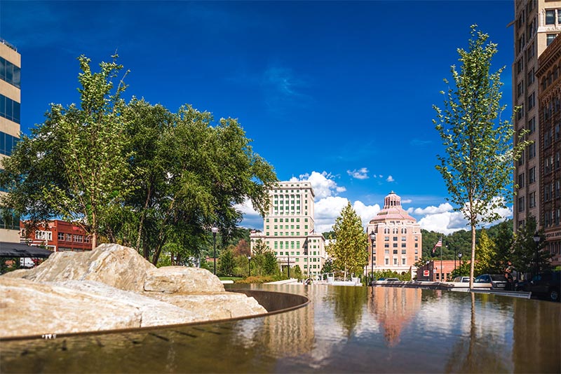 A view from across a fountain of a few high-rise buildings in Asheville