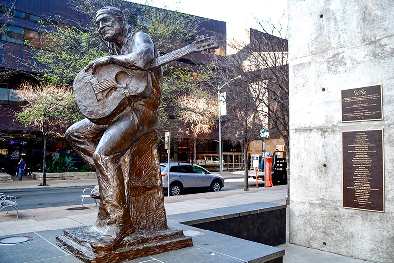 A bronze statue of Willie Nelson in Downtown Austin Texas