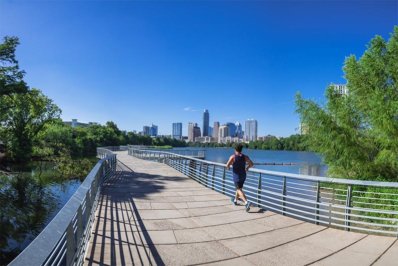 A person running on a pedestrian bridge in Austin Texas