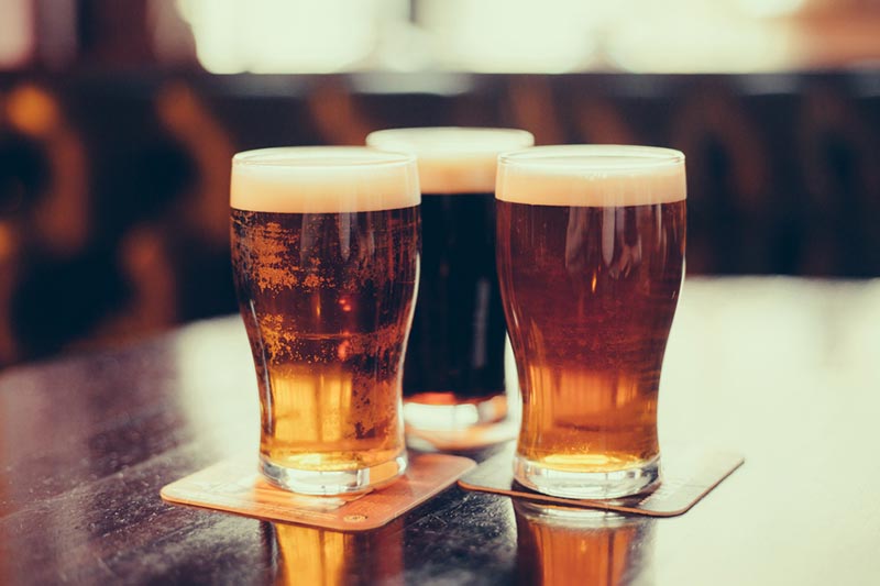 Pints of beer on coasters at a brewery