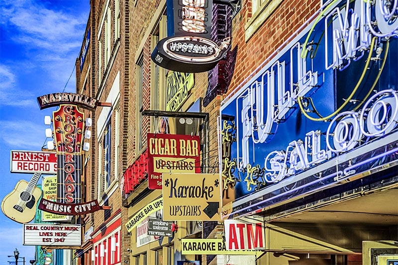 A flat view of neighboring buildings in SoBro Nashville with many colorful neon honky tonk signs