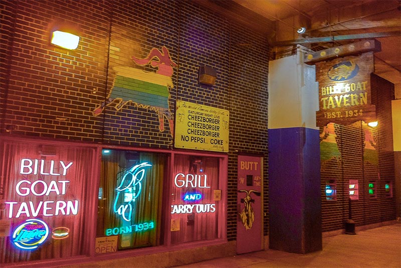 The outside facade of the historic Billy Goat Tavern in Chicago with its neon signs