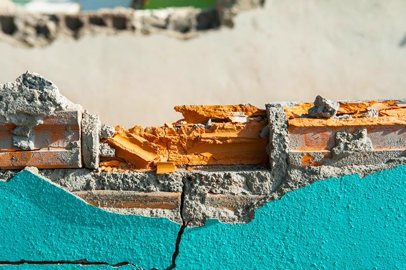 Damaged stucco and brick wall