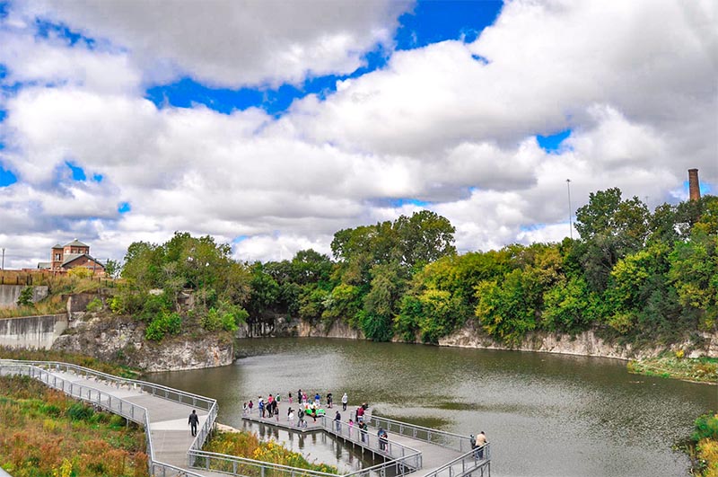 A view of a ravine with tourists along a pier at the Henry C Palmisano Nature Park in Bridgeport Chicago