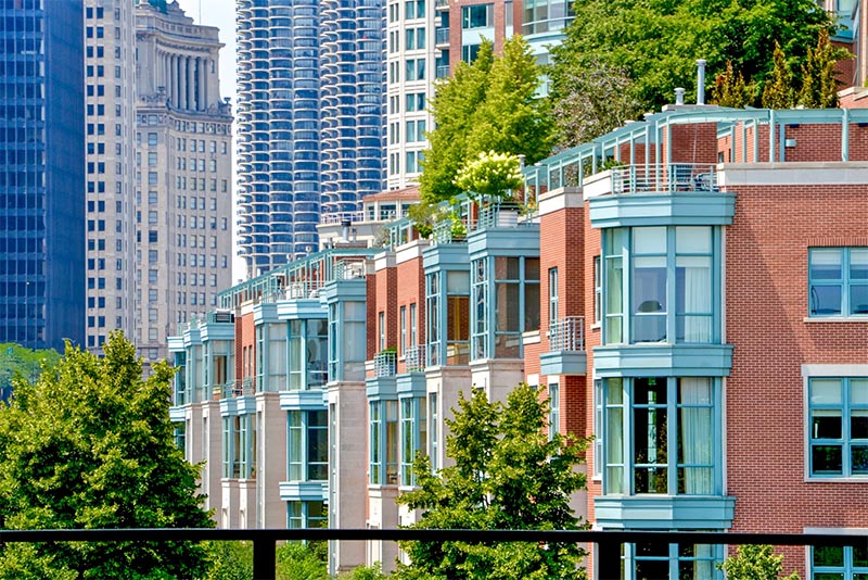 A row of townhomes in Chicago with buildings behind