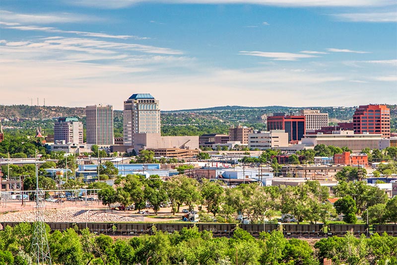 The skyline of Colorado Springs with a few high-rise buildings and an even landscape