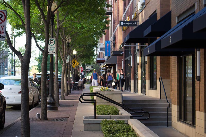 A street in Dallas Texas with shops all along the right side of the image