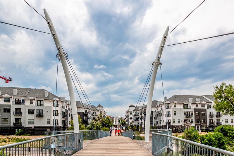 A suspended foot bridge crosses to a residential area in Denver Colorado