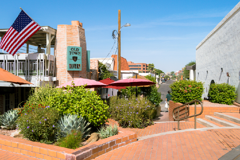 Outdooor view of colorful stucco restaurant in Old Town Scottsdale with outdoor seating and sign that says Old Town tavern,