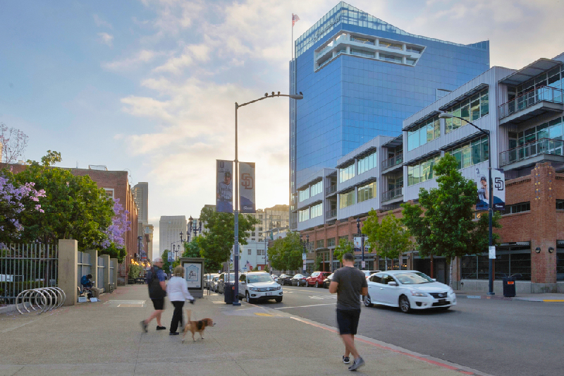 People walking Downtown San Diego with skyscrapers in background.