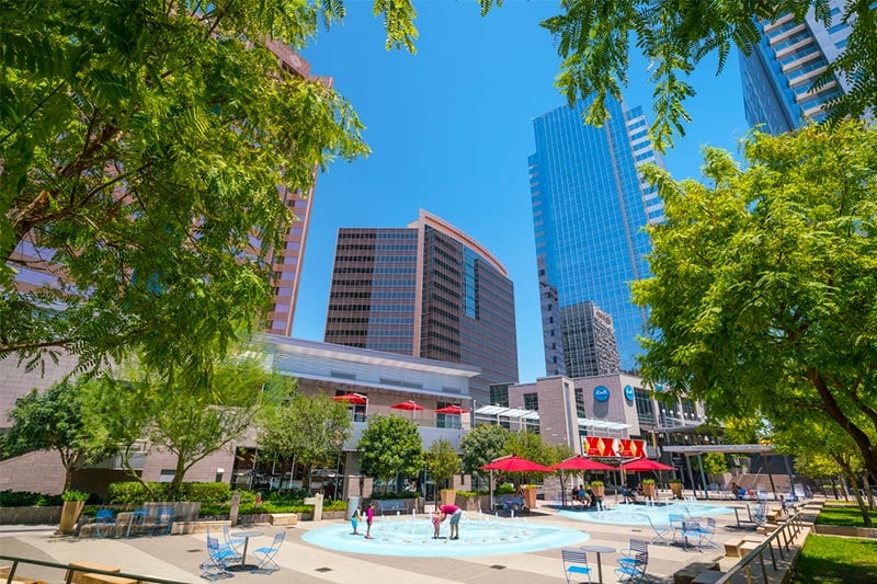 Downtown Phoenix skyline with family playing in fountains of water