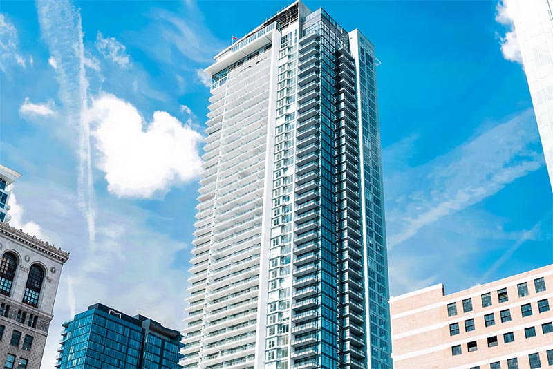 A very tall condominium building rises above the rest of the skyline in Downtown Los Angeles