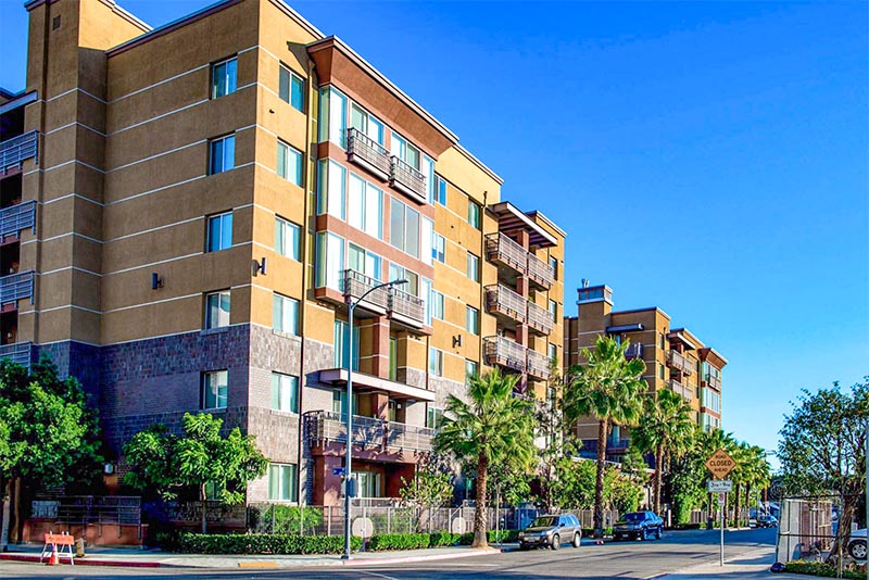 A small condominium building in Downtown Los Angeles surrounded by palm trees