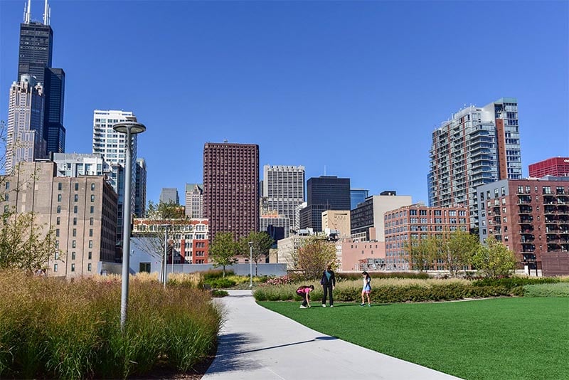 People walk through a green park in the heart of the Loop in Chicago's South Loop