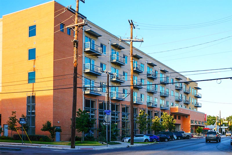 A brick condominium building against a blue sky in Tobin Hill San Antonio