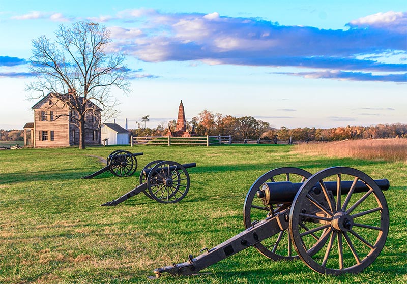 Old cannons and the Ford House in a field at Manassas National Battlefield Park