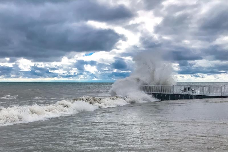 A lake wave crashes up on a pier in Glencoe Illinois outside Chicago
