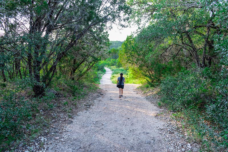 A person walking down a path in Government Canyon State Park in San Antonio