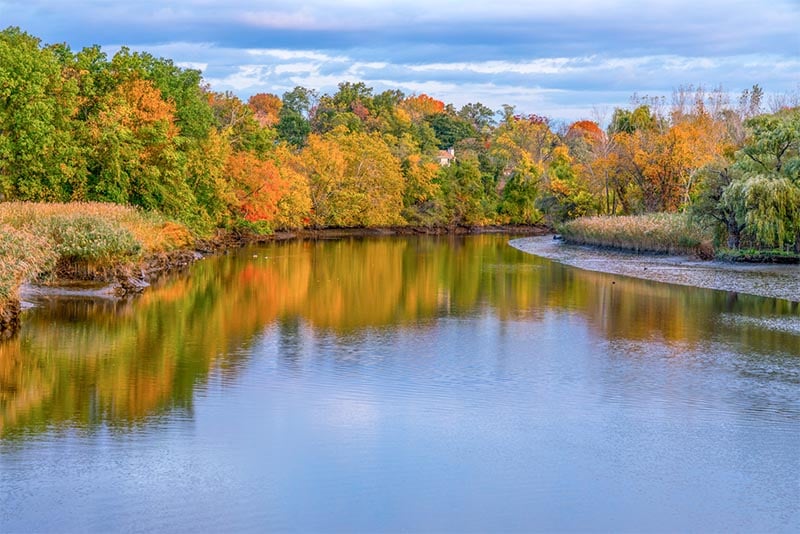The Hackensack River with fall foliage around it