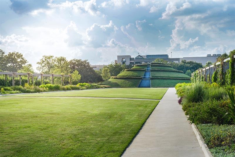 A wide view of Centennial Gardens in Houston with the tiered waterfall at its center