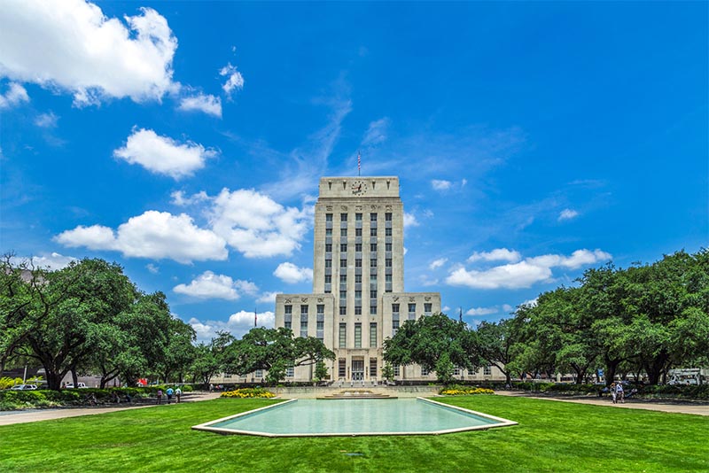 Houston City Hall rises above the landscape and a fountain in Houston Texas