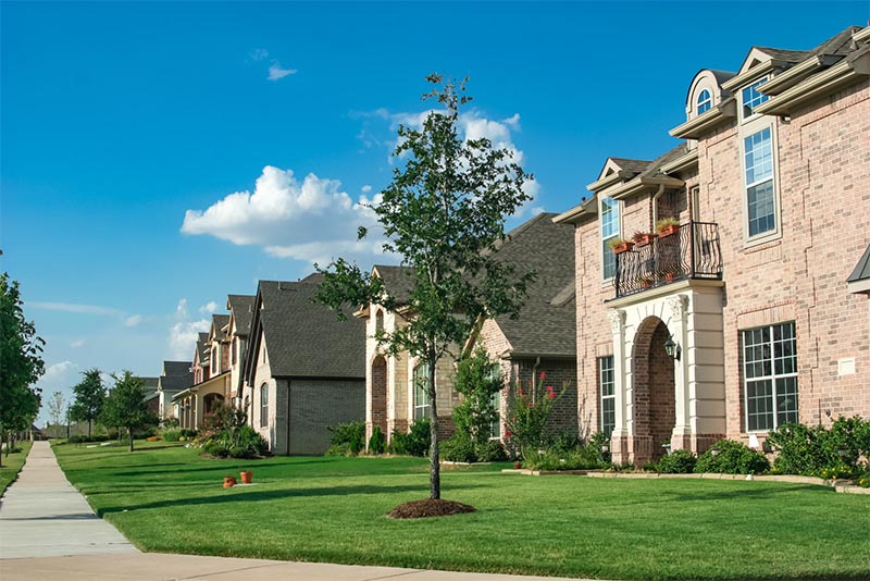 A residential street in Houston with large homes on the block