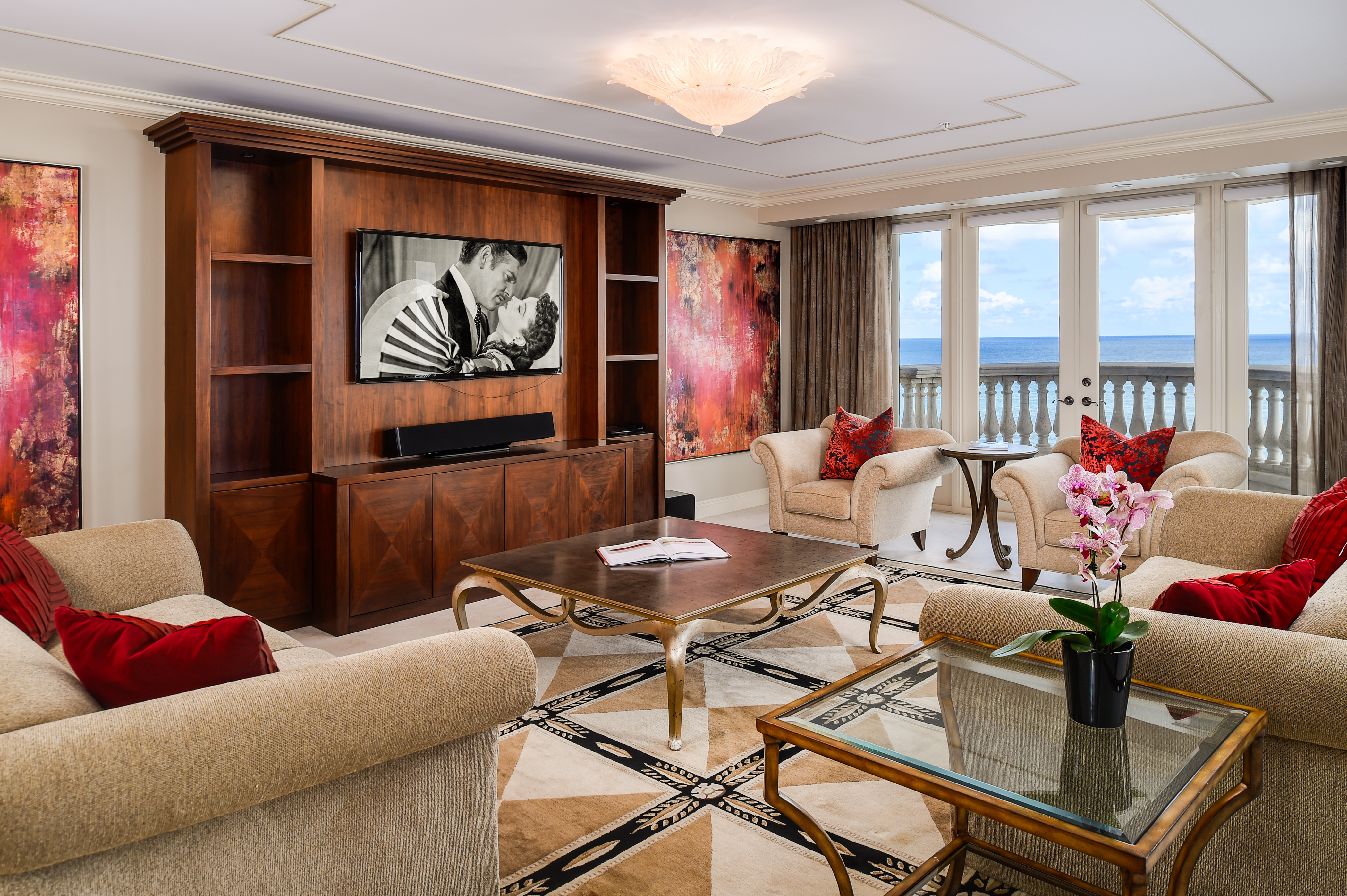 Interior of a luxurious living room with ocean views and Gone With the Wind playing on the TV.
