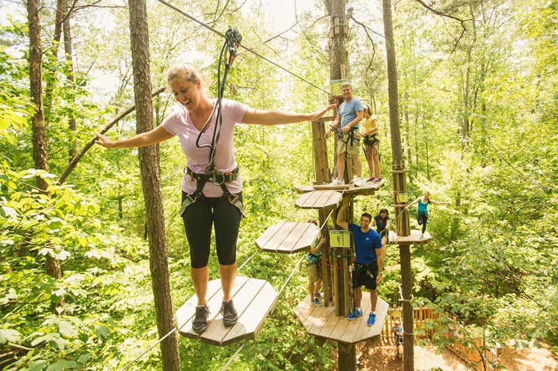 A family enjoying a treetop adventure course in Bemis Woods in Western Springs, Illinois
