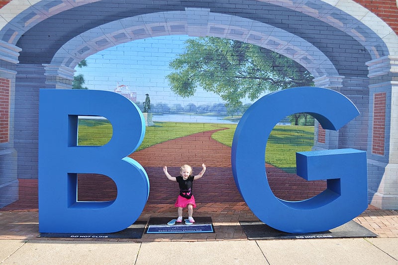 A little girl posing with a sculpture in the Bishop Arts District of Dallas, Texas