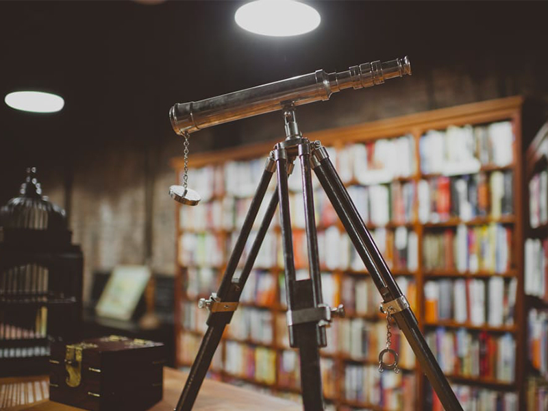 Large bookshelf and telescope at Uncharted Books in Chicago's Logan Square neighborhood.