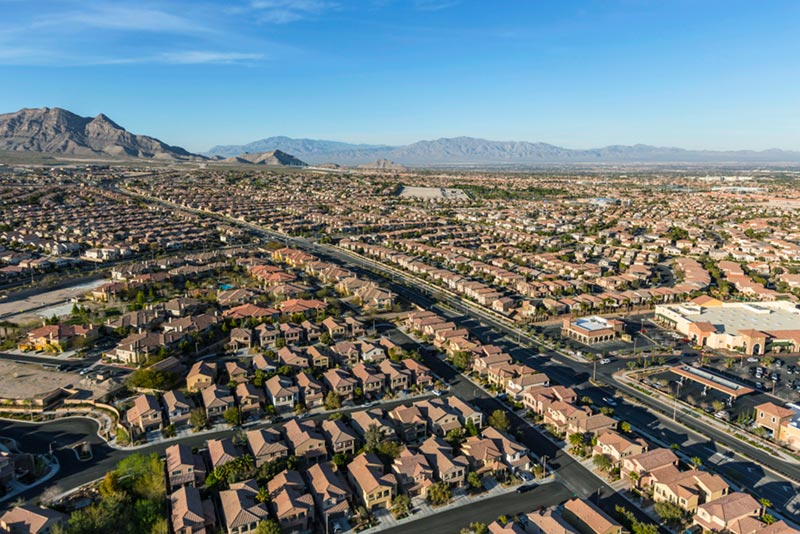 Aerial of homes and neighborhoods in suburban las vegas and mountains in distance.