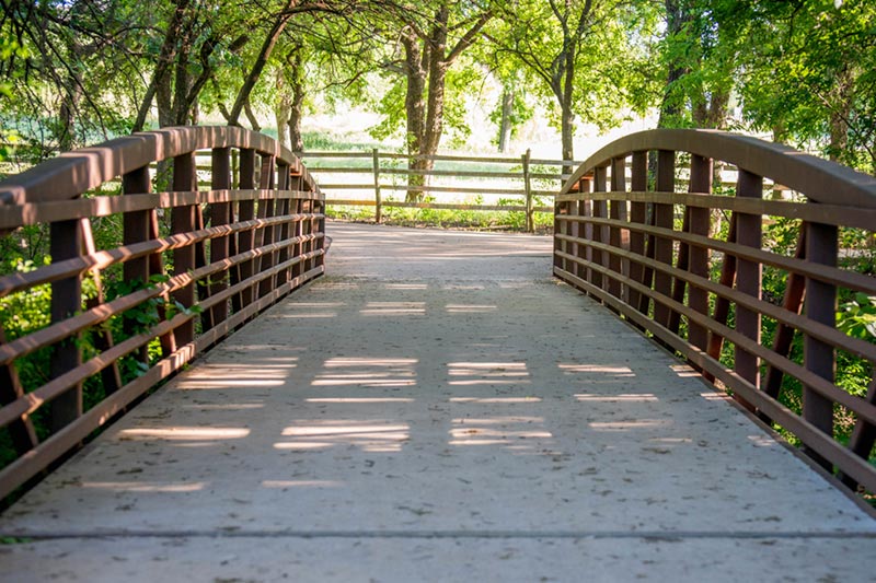 A pedestrian bridge over a small creek at Keller Pointe Park in Keller, Texas