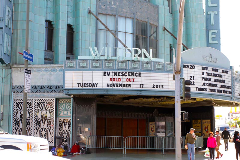 Exterior of concert marquee with people crowded outside.