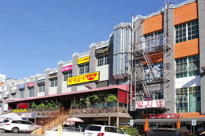 apartment buildings with construction on exterior and parking lot