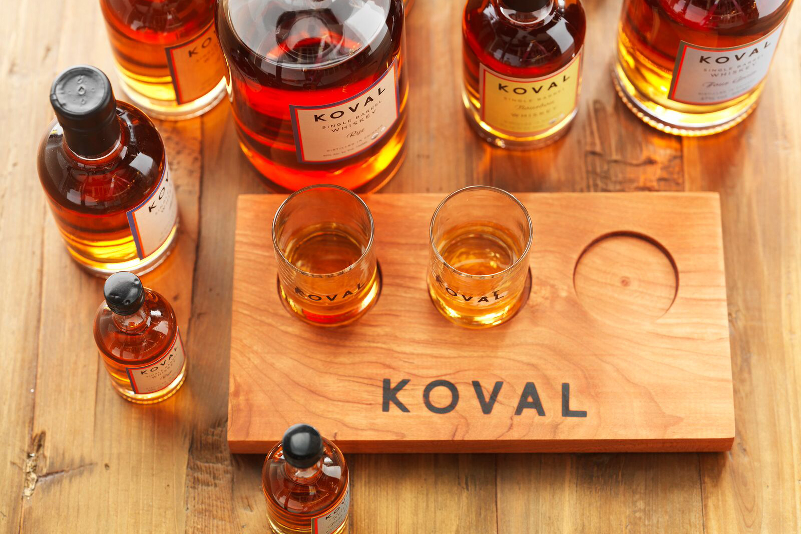 Looking down at several different glasses of whiskey on a Koval whiskey tasting board.