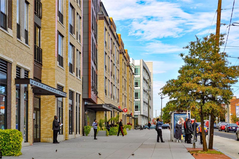 condo buildings with residents walking in and out and on street