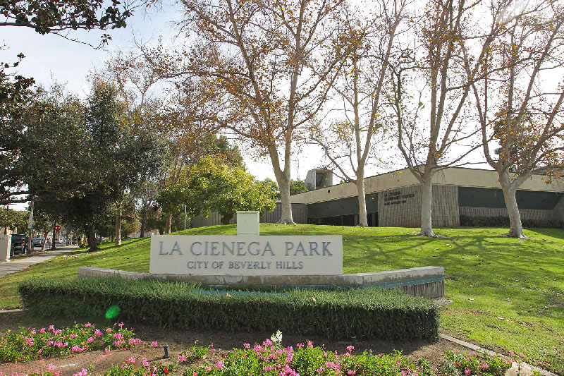 Sign for La Cieniga PArk in Beverly Hills with community center in background.