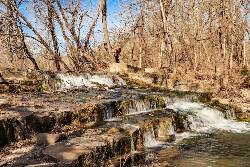 A small waterfall surrounded by forest in Lockhart Texas
