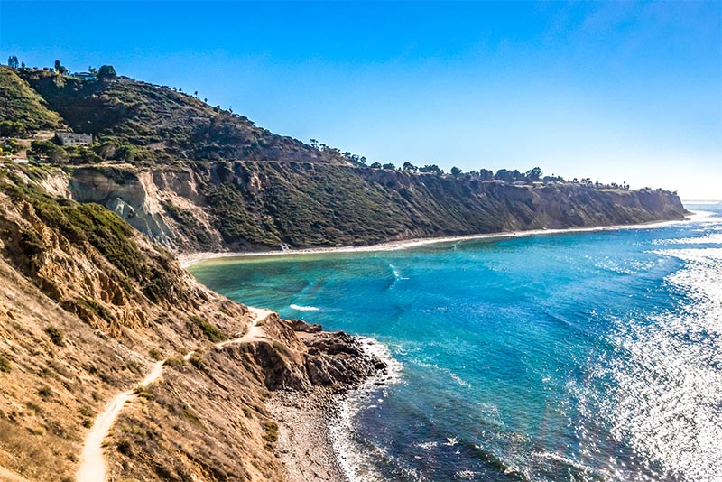 A beautiful blue cove of water and tall dark cliffs in the Los Angeles area