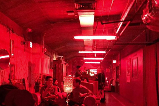 Long view of a secret bar in Phoenix with red lights.