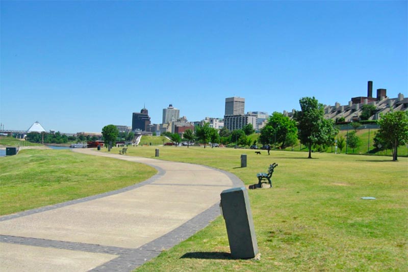 View of path and grass in Memorial Park with Hendersonville skyline in the background.