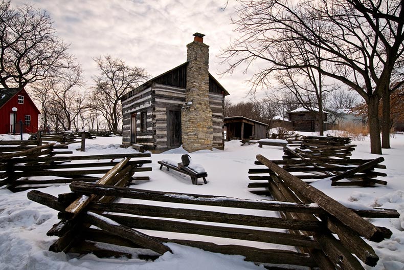 Snow around a log house at Naper Settlement in Naperville, Illinois